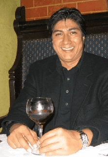 A man sitting in front of a wine glass.