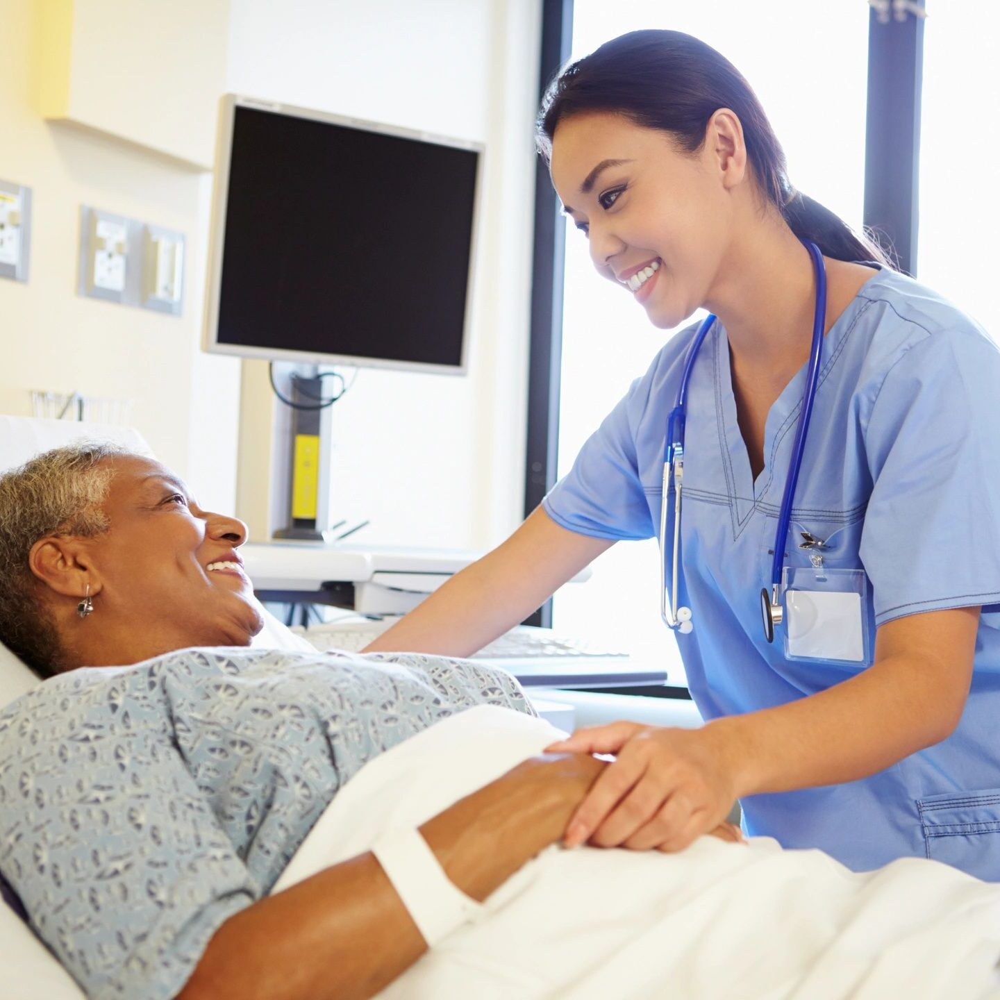 A nurse is caring for an elderly patient in the hospital.